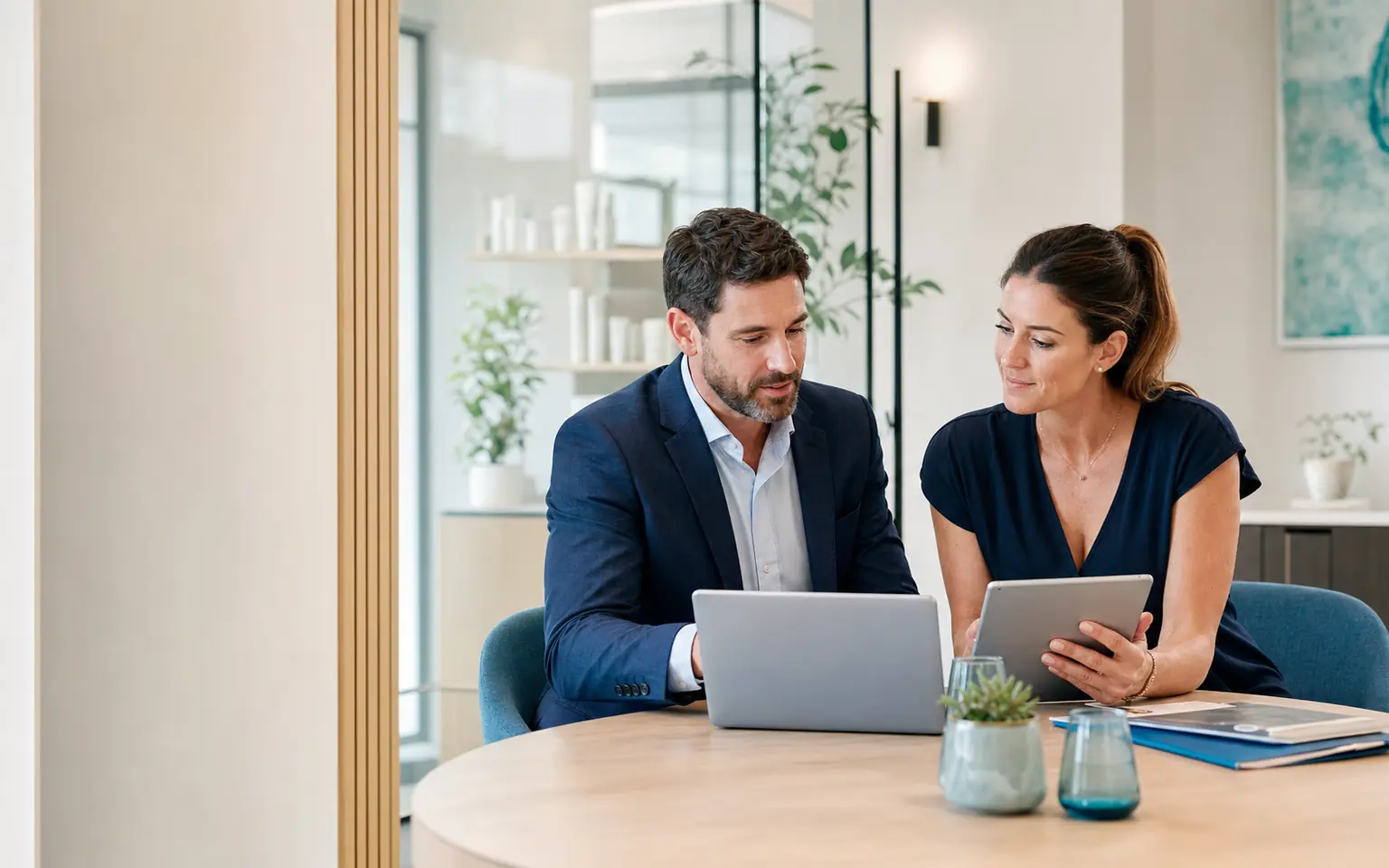 An insurance adviser and clinic owner reviewing information together in a modern office.